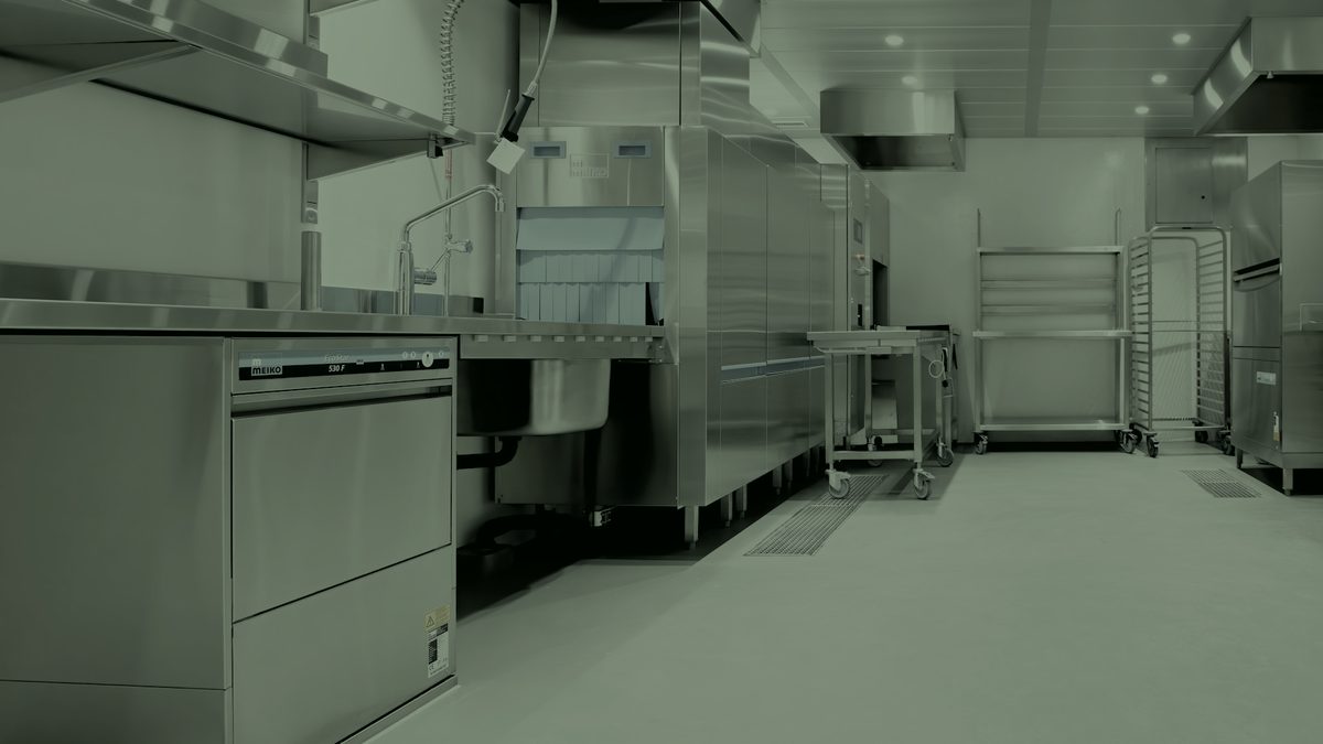 A newly fitted commercial kitchen, stainless benching and racking in place.
